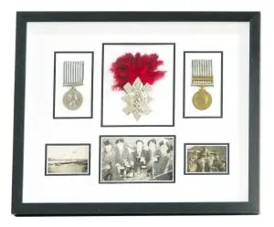 Framed medals in black and white mount, in a multi-aperture frame.
