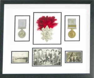 Framed medals in black and white mount, in a multi-aperture frame.